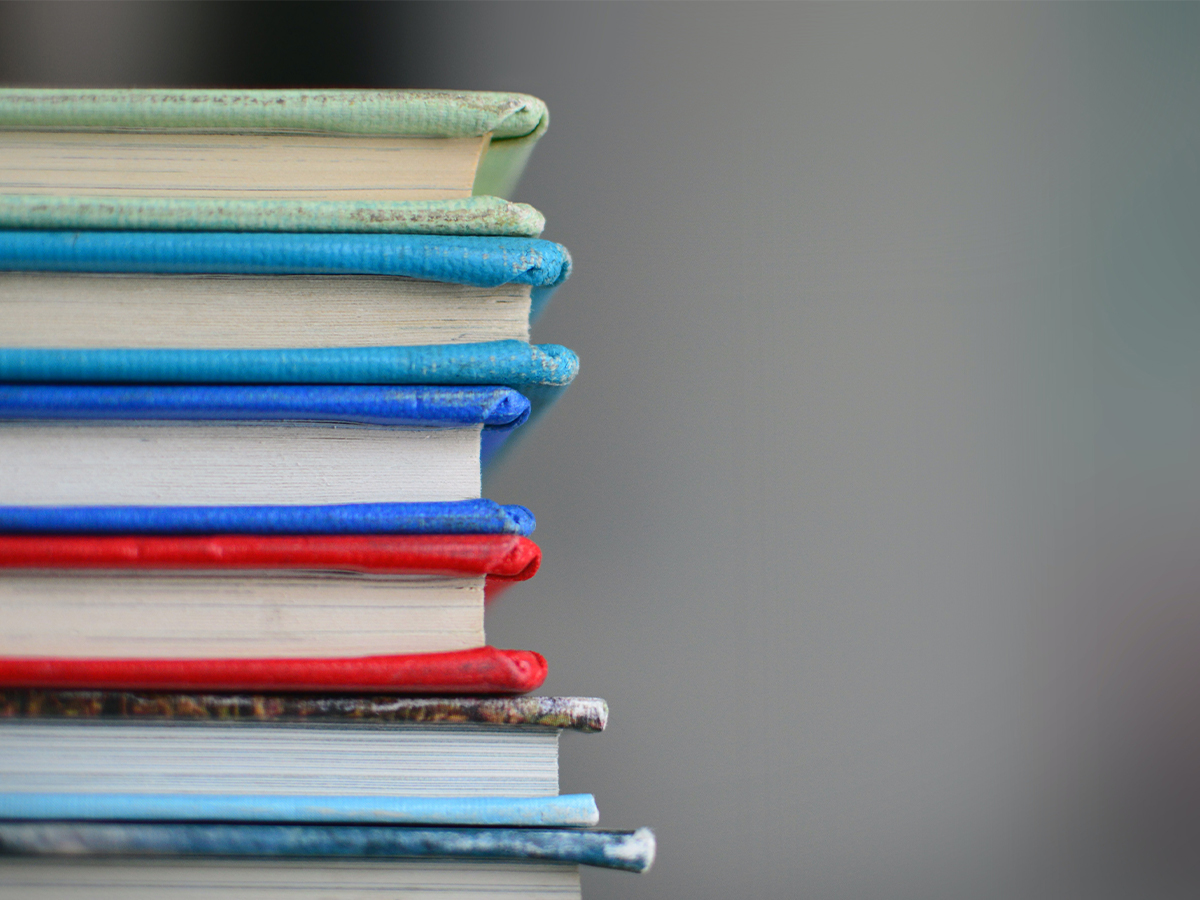 Several text books stacked on top of each other