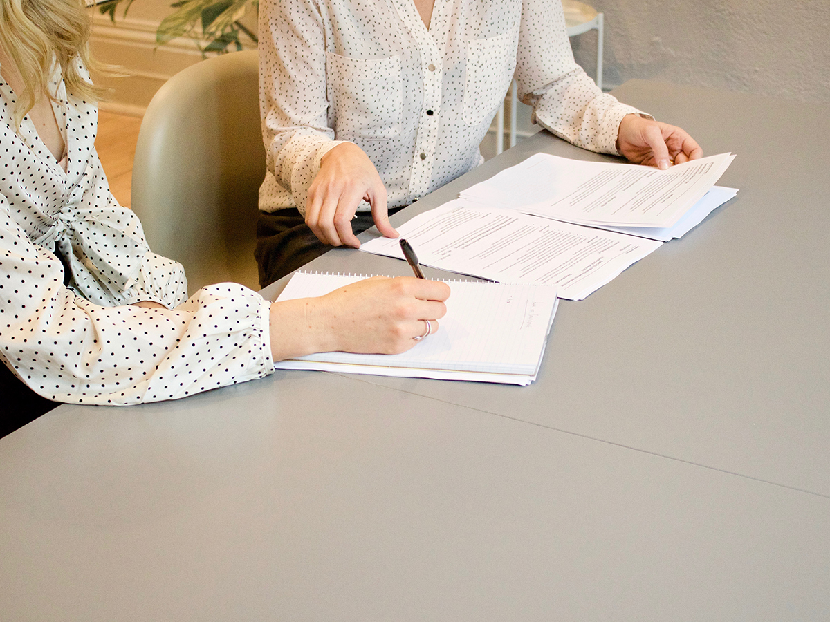 Two women discussing something with one taking notes