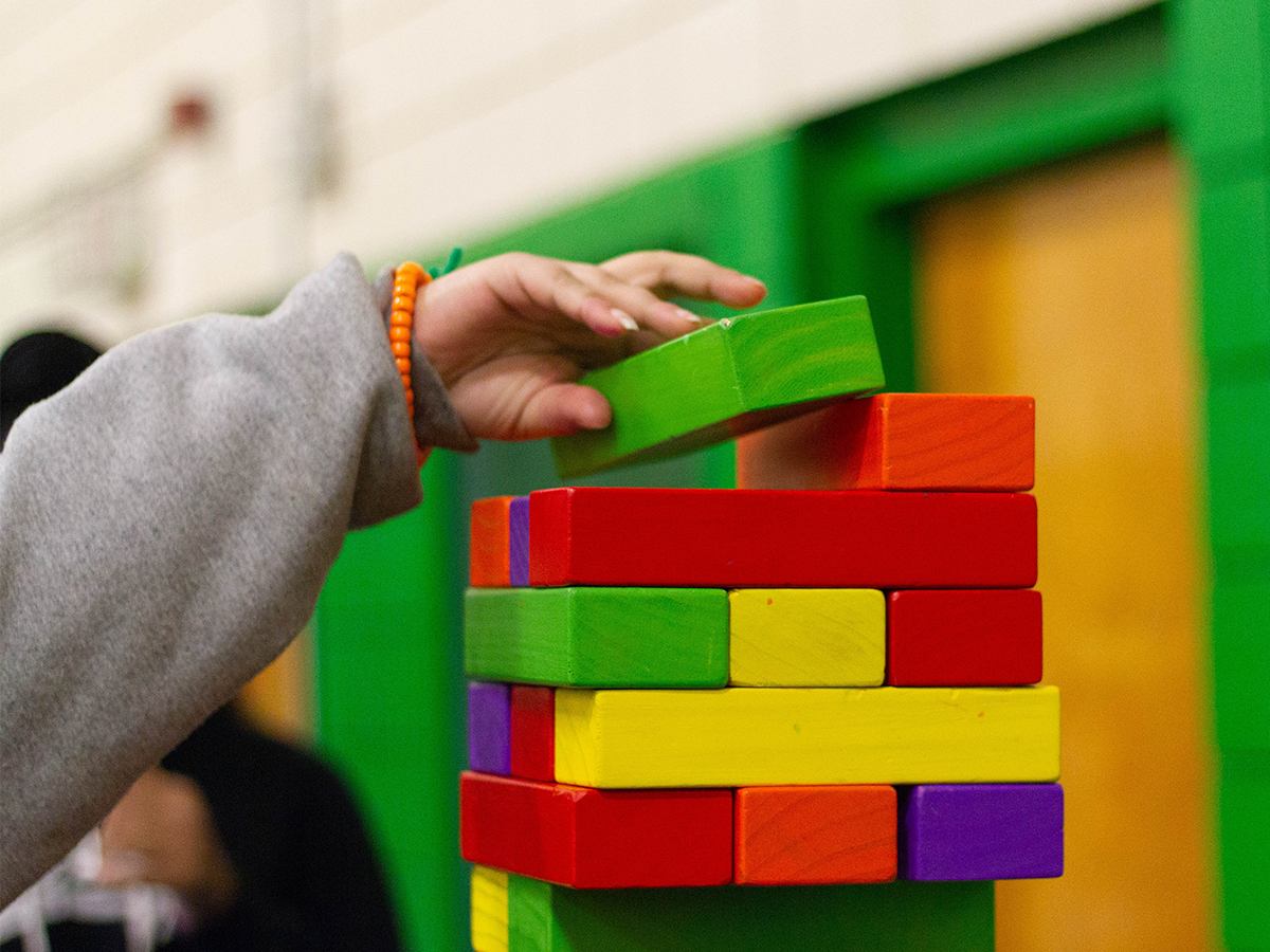 Child stacking multi colored blocks into a tower