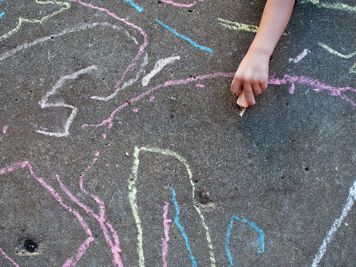 Toddler drawing with sidewalk chalk