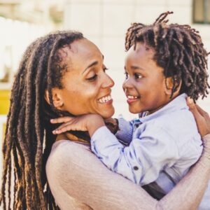 african american teacher holding an african american student