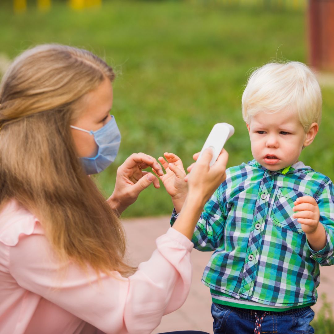 preschool staff with thermometer