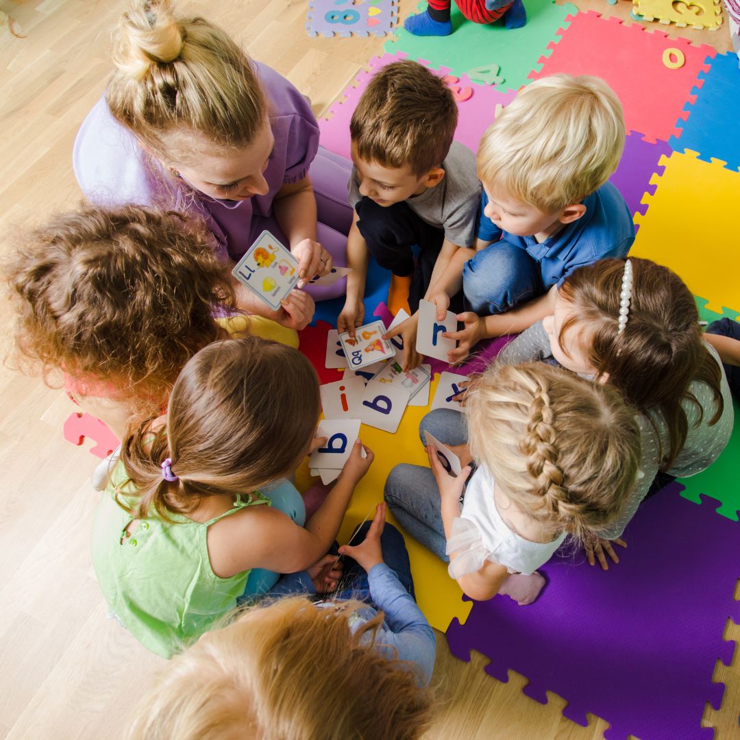 Daycare teacher showing alphabet cards to children
