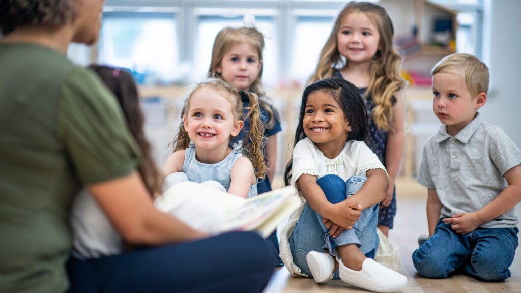 a daycare class listening to their teacher read a book