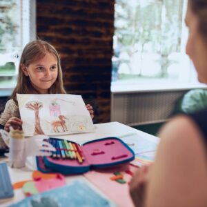 Girl showing a drawing to someone.