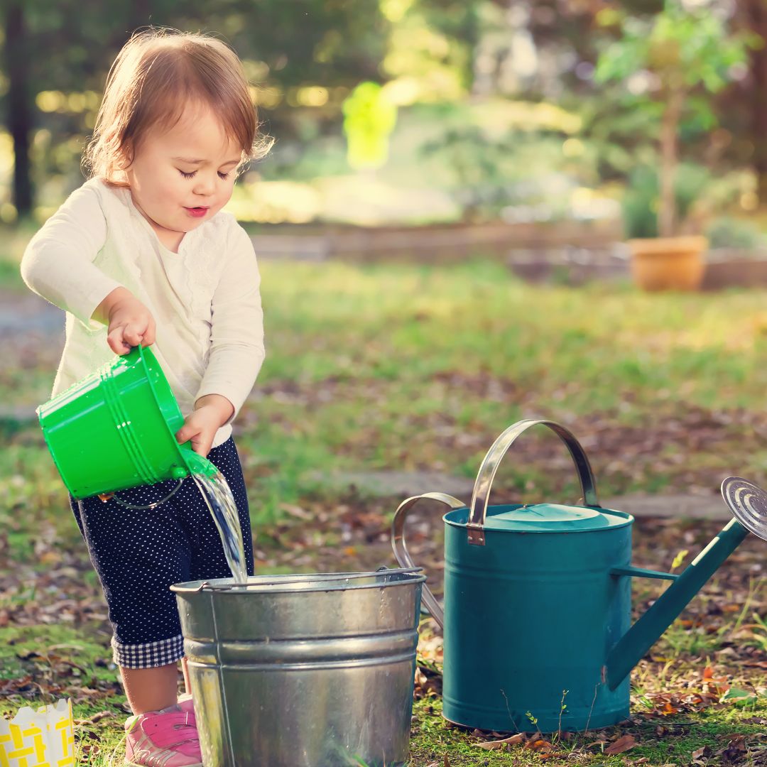 toddler pouring water from bucket to another