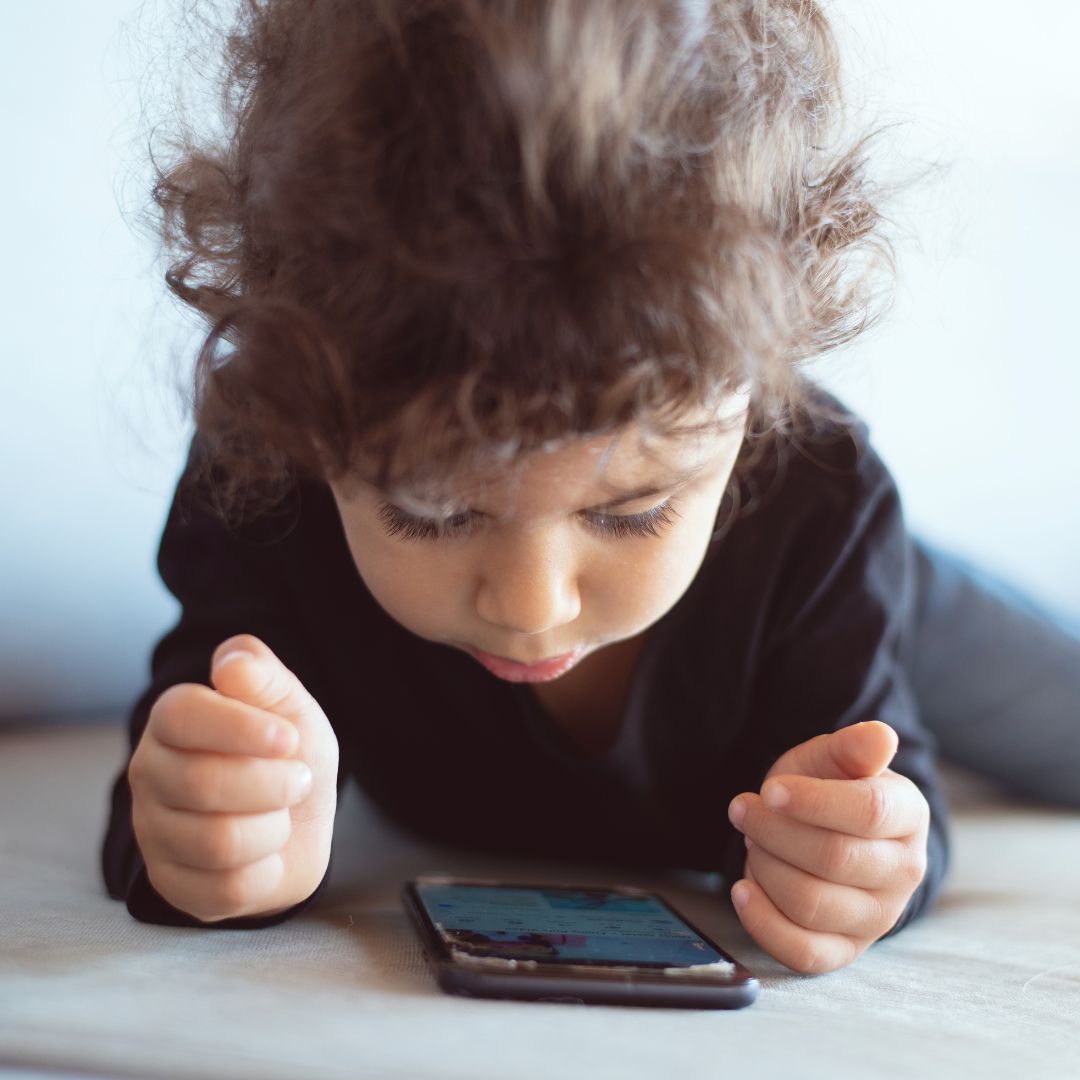 little boy looking at a phone screen